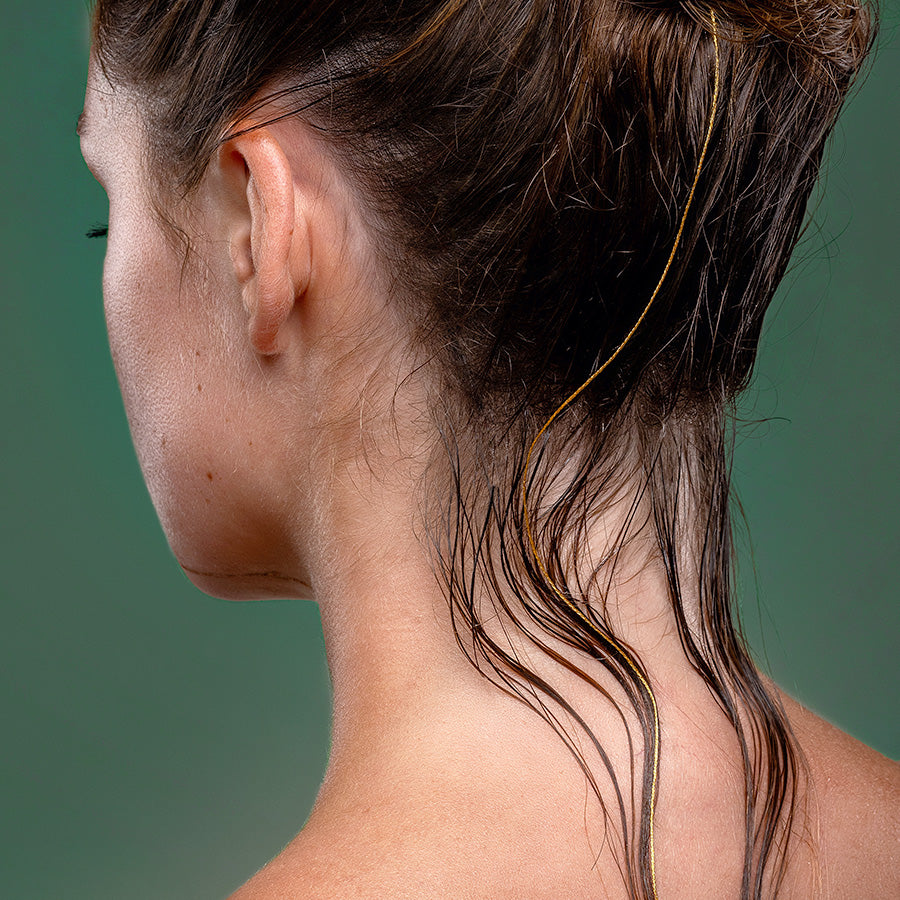 Conditioner wird auf Haarsträhnen aufgetragen für weiches, gesund aussehendes Haar mit natürlichem Glanz